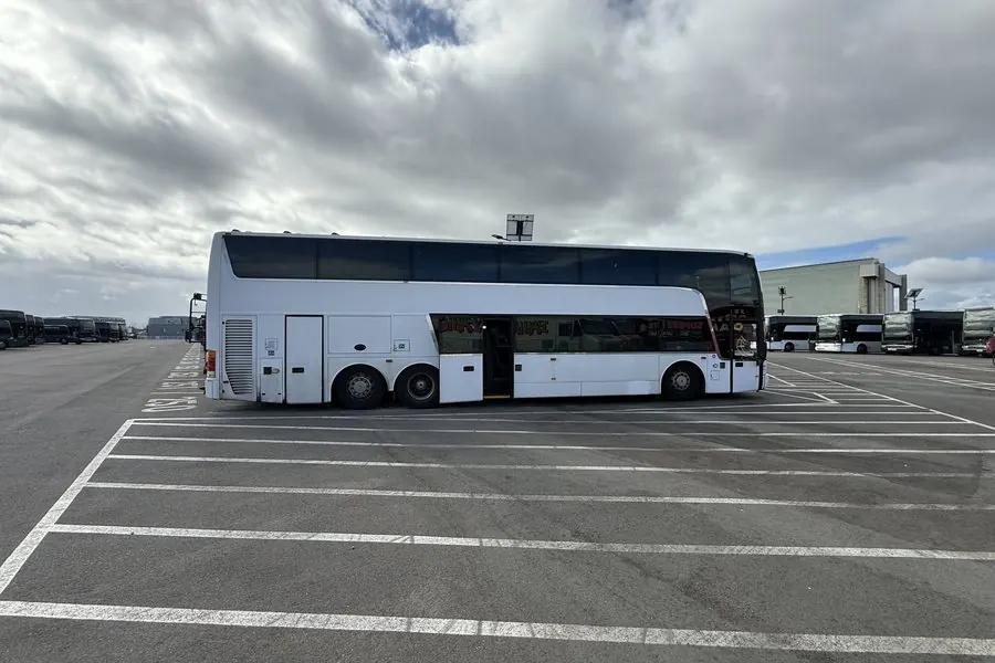 Side view of a white Van Hool TDX25 Astromega double-decker coach owned by Umbrella Global Bus
